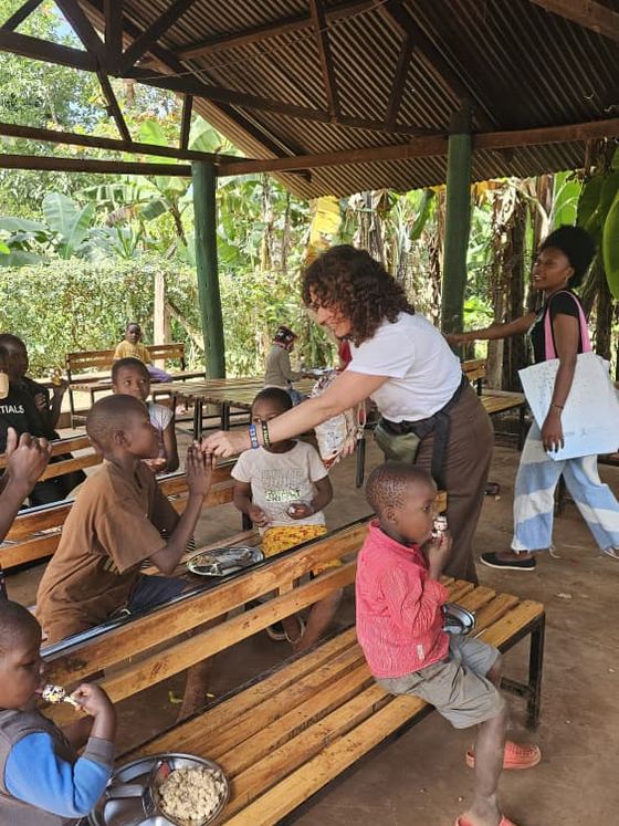 Una integrante del equipo reparte la merienda entre los niños en el comedor.